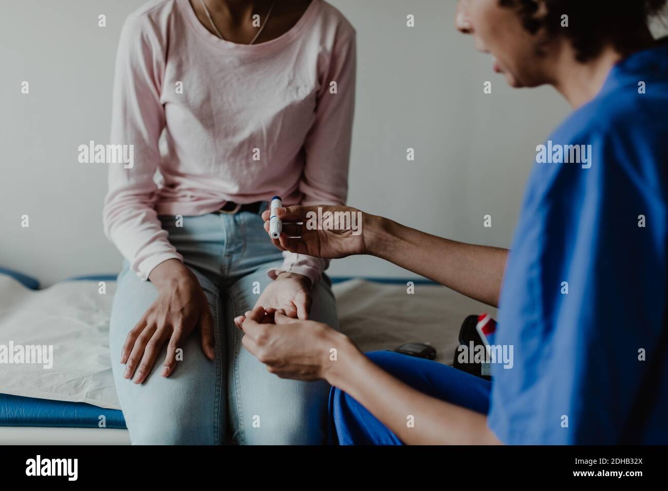 Infermiere controllo glicemia paziente in sala esame medico Foto Stock