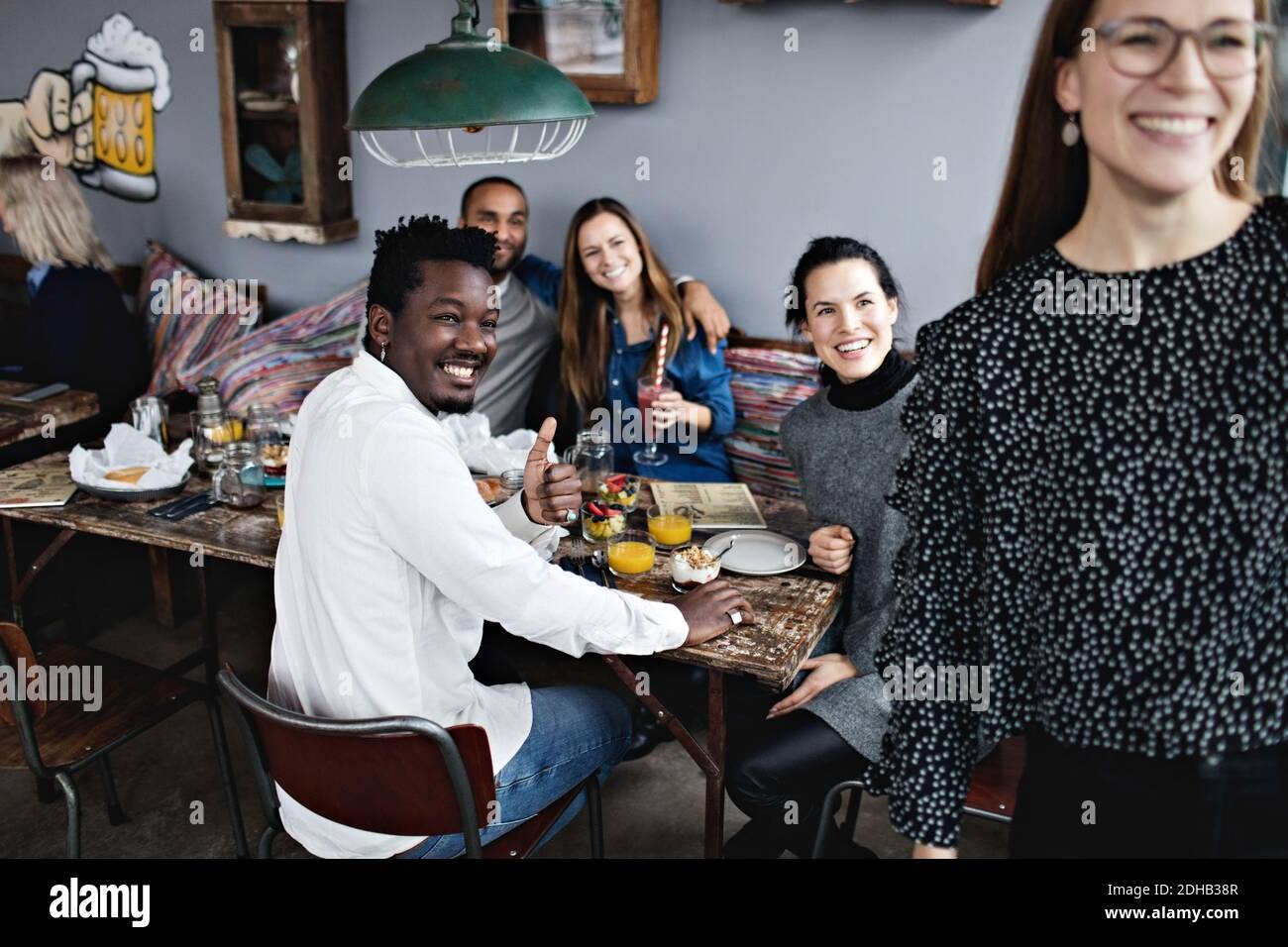 Allegri amici multietnici che si gustano il brunch al ristorante Foto Stock