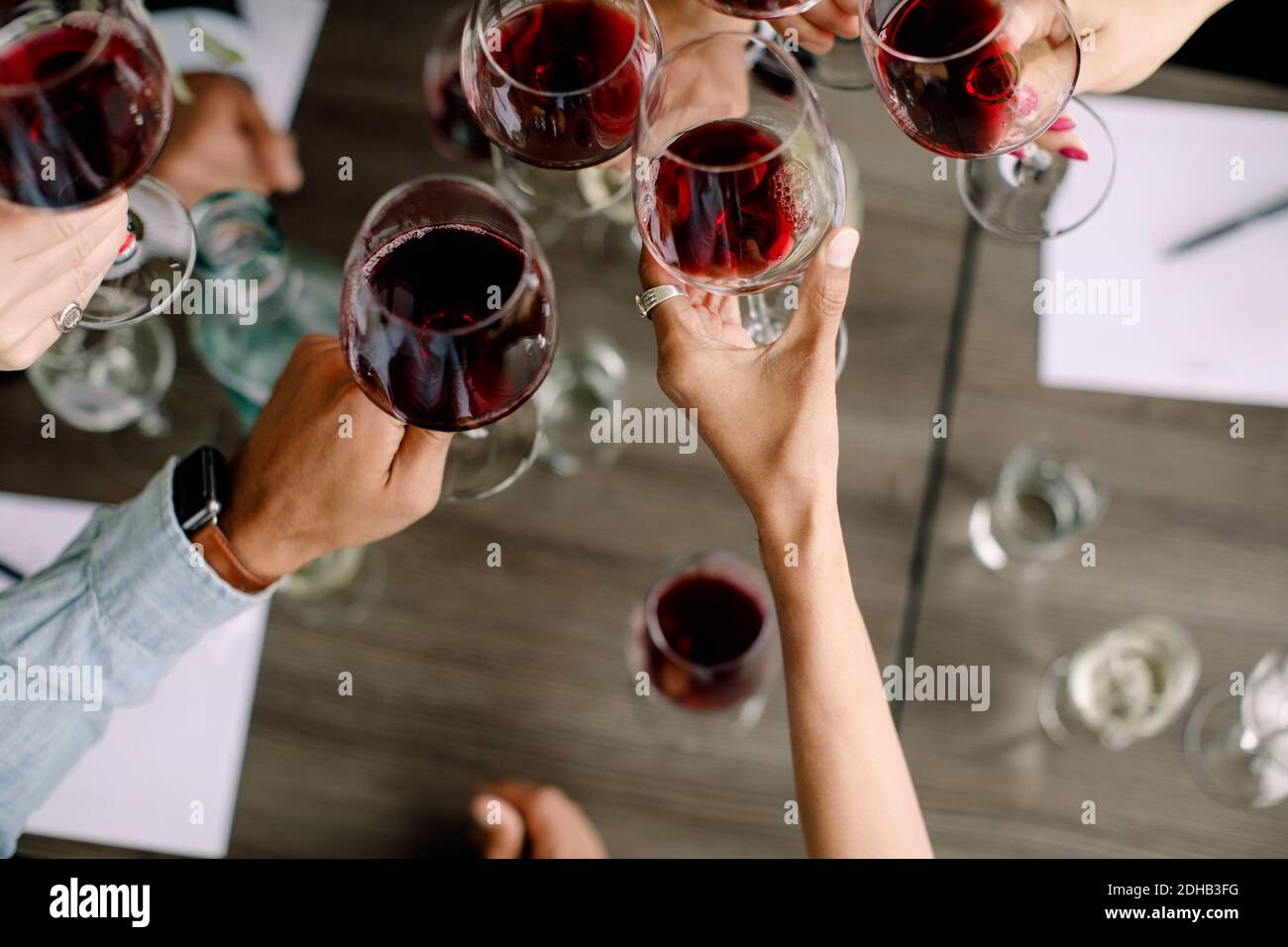 Immagine ritagliata di uomini d'affari e donne d'affari tostando gli occhiali da vino sopra la tabella al centro congressi Foto Stock