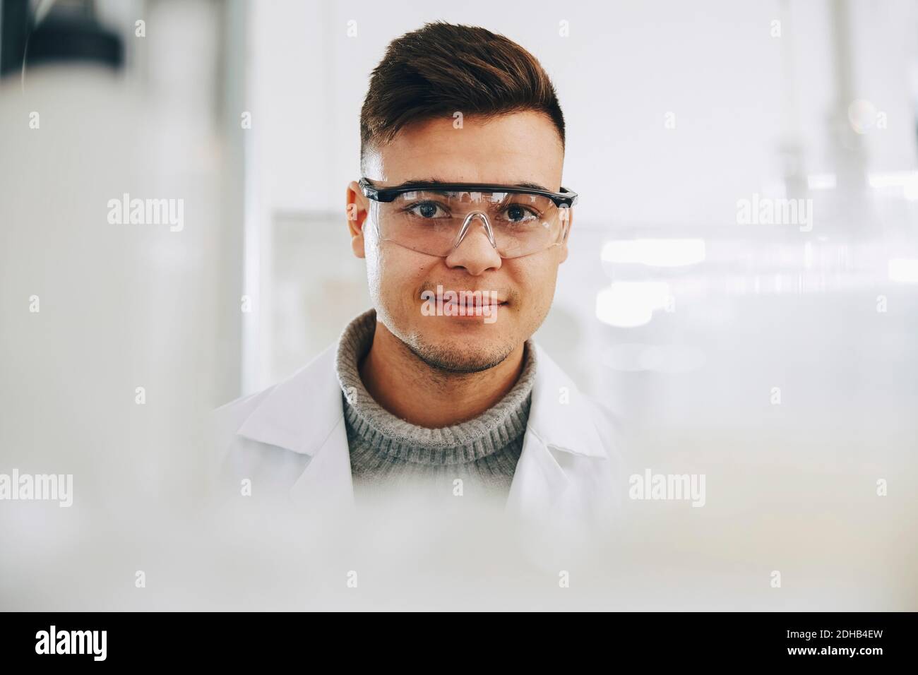 Ritratto di giovane studente di chimica sicuro che indossa occhiali in laboratorio Foto Stock