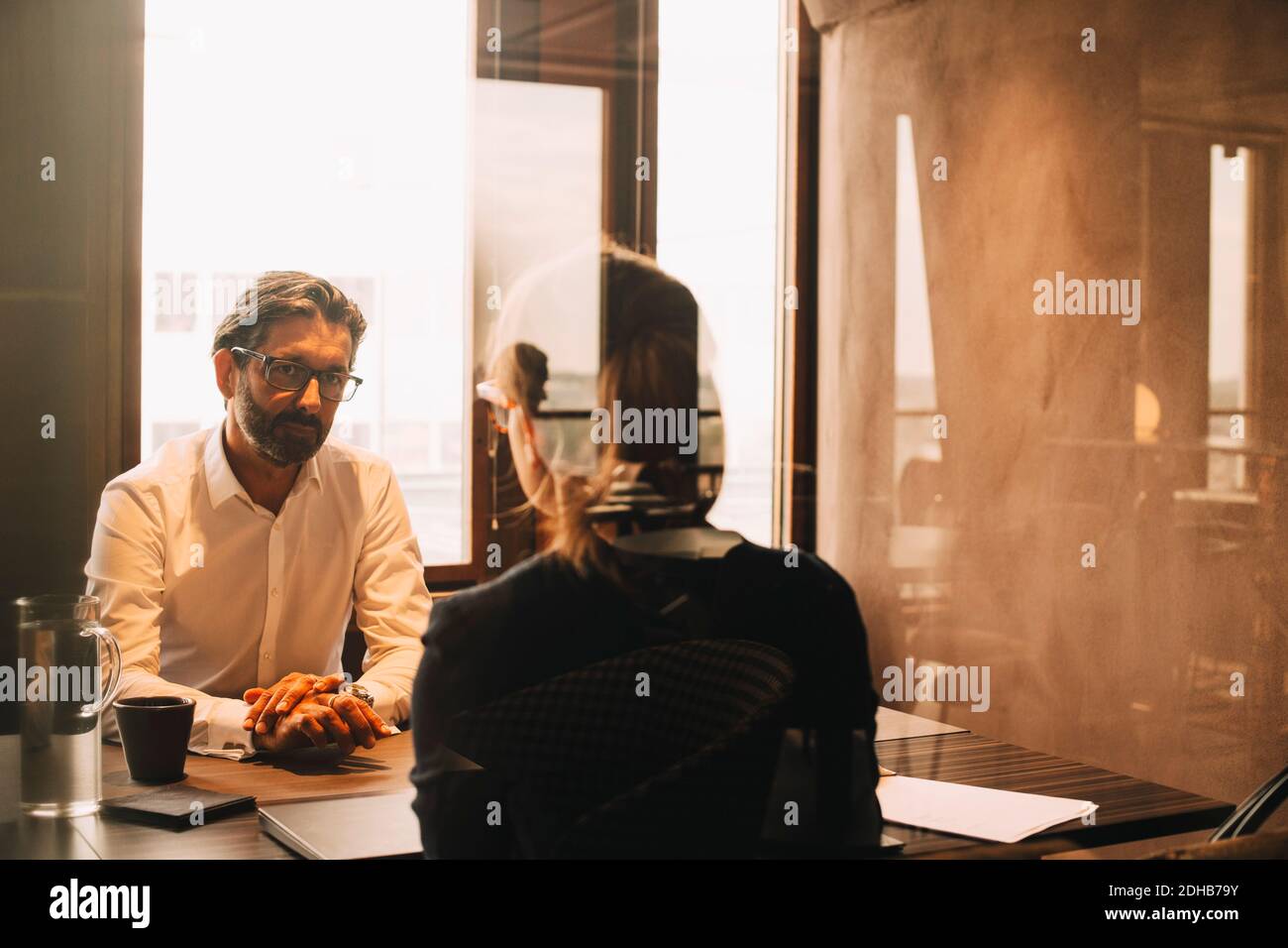 Cliente maturo che ascolta la donna avvocato in riunione di ufficio Foto Stock