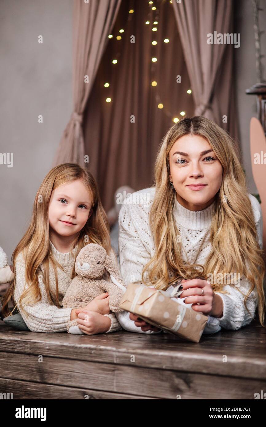 Madre felice e piccola figlia che tiene i regali di Natale a casa Foto Stock