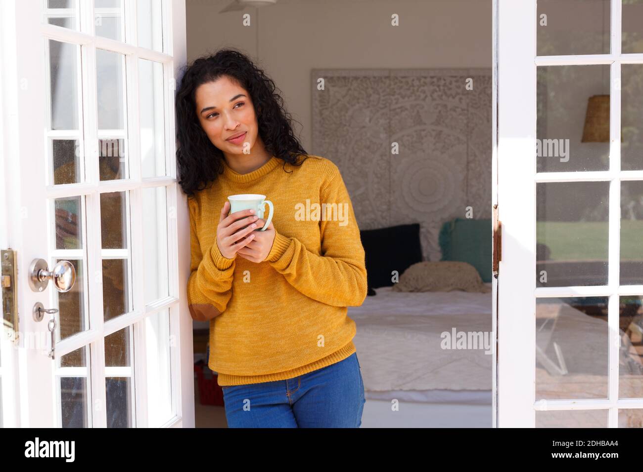 Misto razza donna in piedi nelle porte bere tazza di caffè Foto Stock