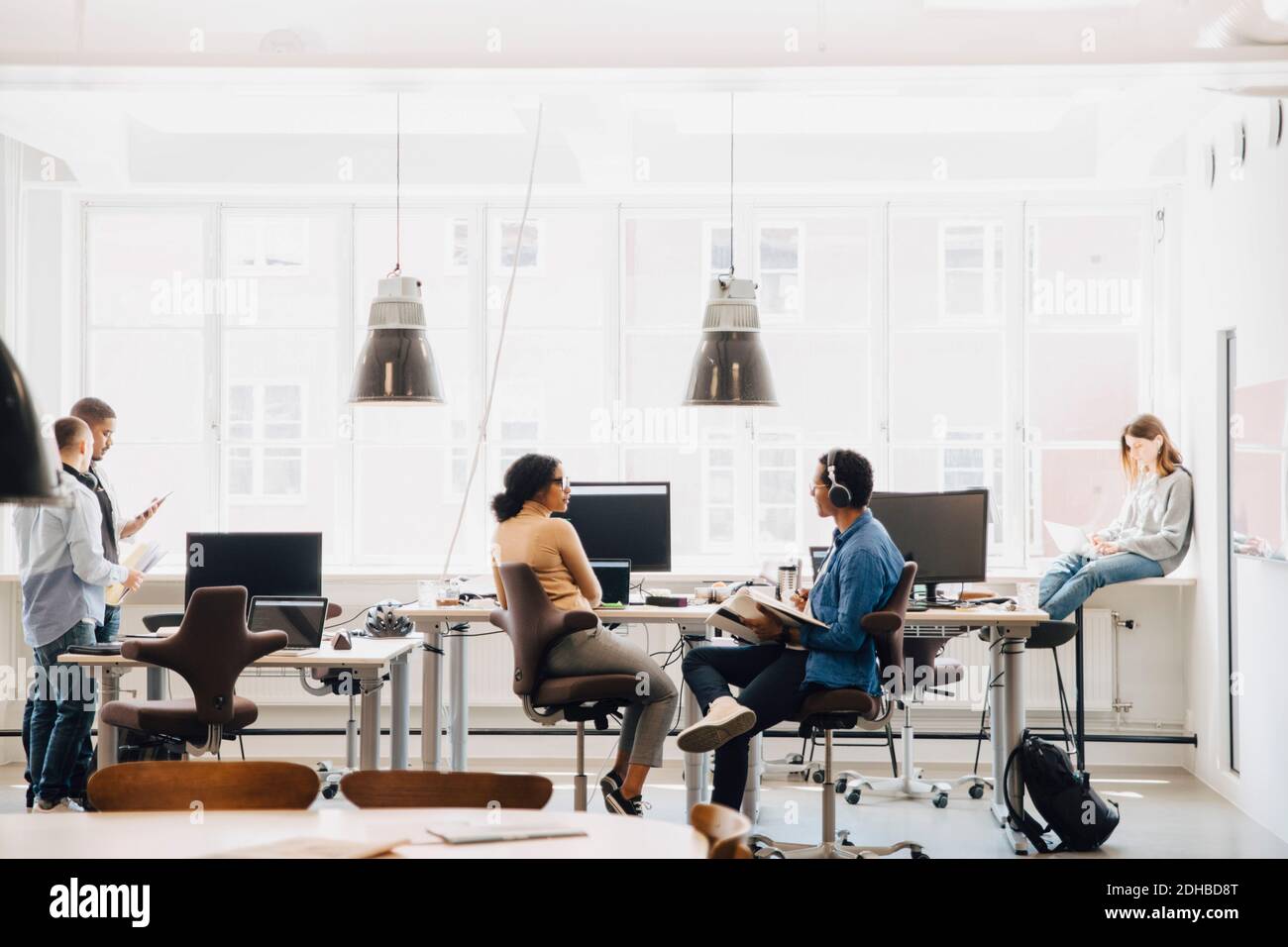 Ingegneri informatici di sesso maschile e femminile che lavorano contro la finestra nella creatività ufficio Foto Stock