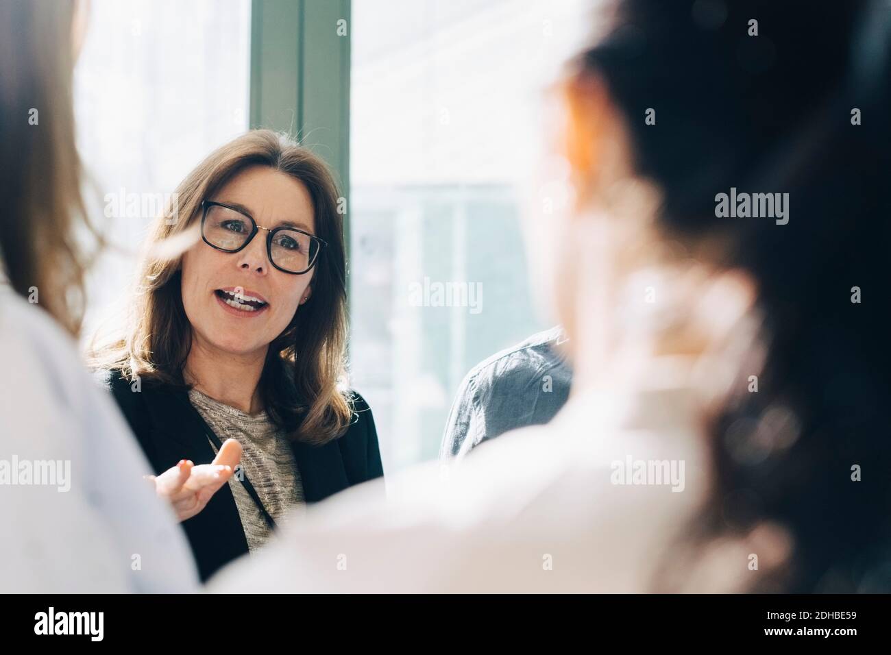 Donna d'affari che condivide idee con i colleghi durante la riunione Foto Stock
