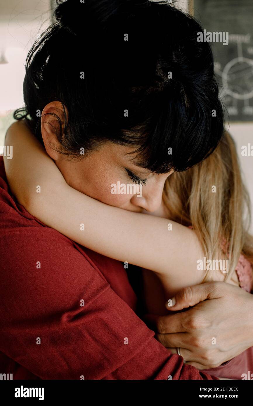 Madre abbracciando consolando la figlia a casa Foto Stock