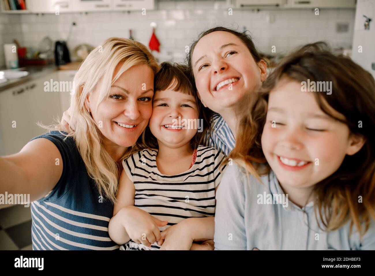 Ritratto di sorridere la madre e le figlie a casa Foto Stock