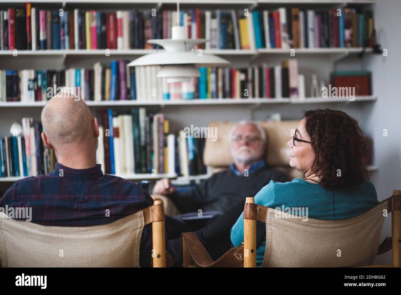 Coppia matura che parla mentre siede con il terapeuta all'ufficio domestico Foto Stock
