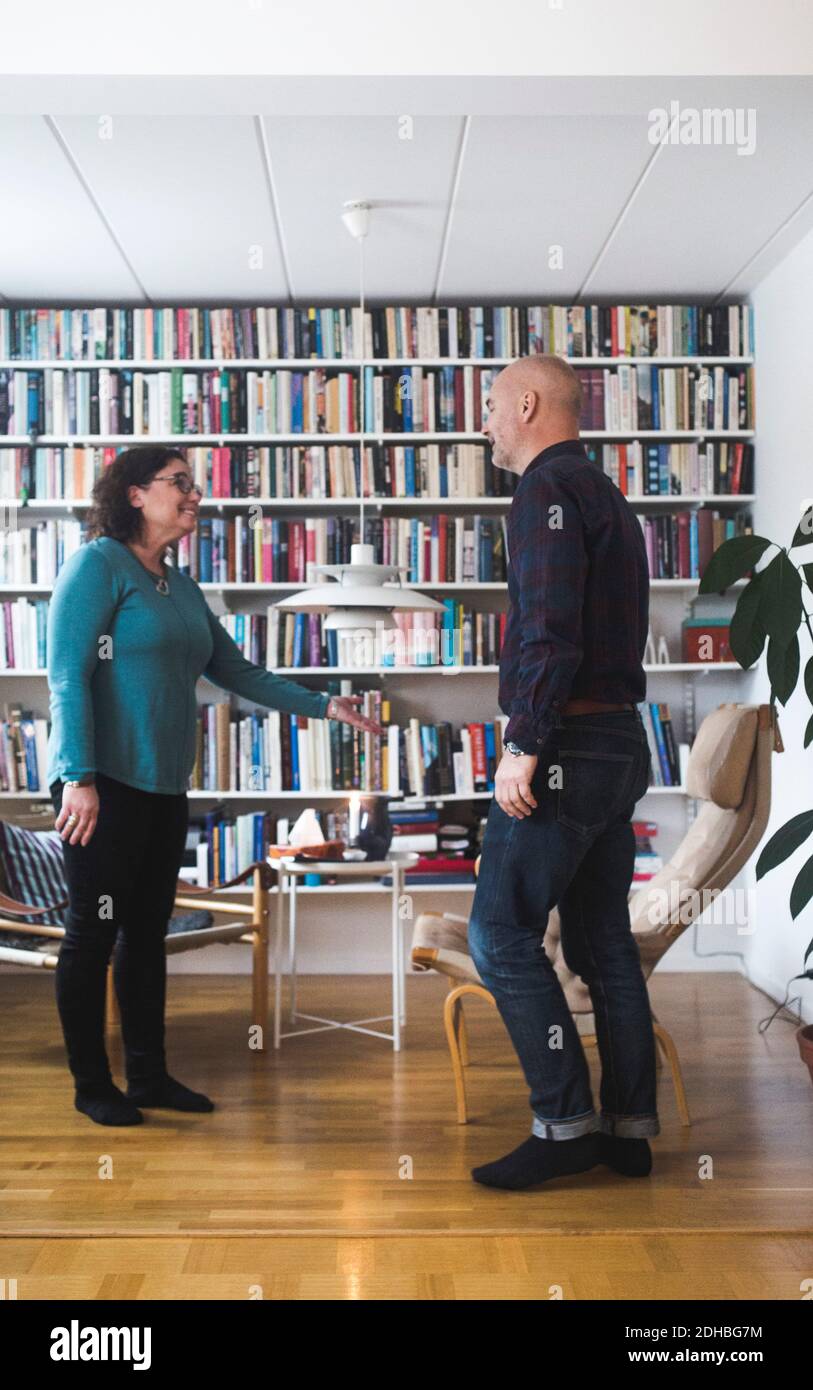 Terapeuta gesturing mentre si parla con il paziente da libreria a casa ufficio Foto Stock