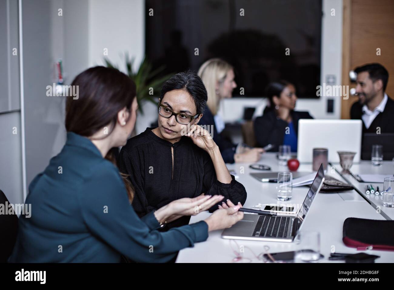 Uomini d'affari che lavorano al tavolo da conferenza nella sala riunioni Foto Stock