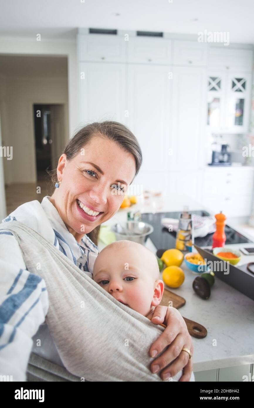 Ritratto di blogger cibo sorridente che porta figlia in cucina a. casa Foto Stock