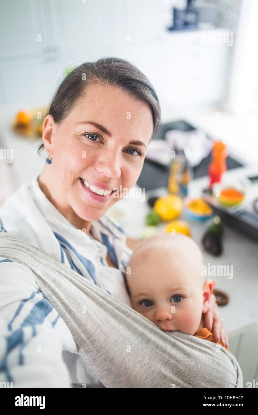 Ritratto ad alto angolo di madre e figlia sorridenti in cucina a casa Foto Stock