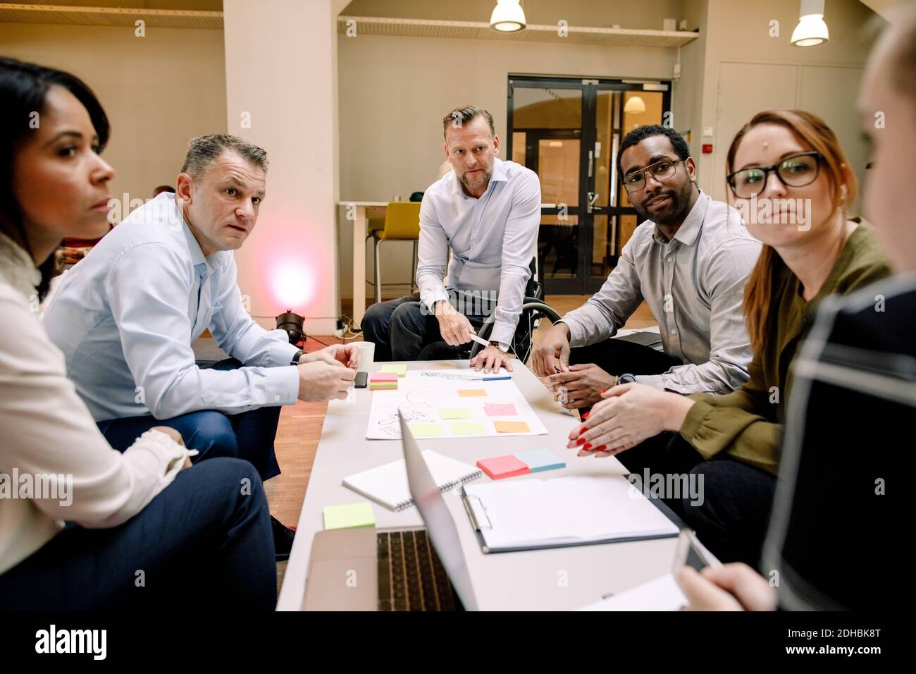 Dirigenti di vendita che guardano una donna d'affari durante la riunione in ufficio Foto Stock