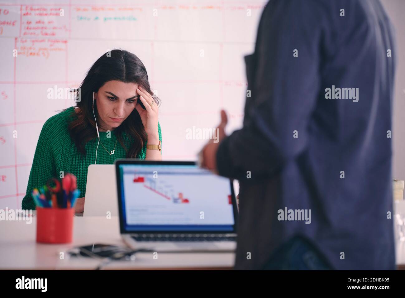 Donna d'affari creativa con un computer portatile alla scrivania in ufficio Foto Stock