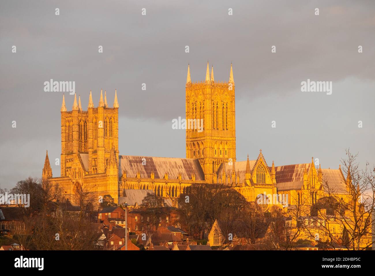 Cattedrale di Lincoln. Nel tardo pomeriggio, quando il sole tramonta il primo fine settimana di dicembre. La foto, ripresa dalla piscina di Brayford, mostra la Cattedrale illuminata da una luce dorata da un sole che tramonta. Non sono stati apportati miglioramenti a questa immagine per modificare il colore. Foto Stock