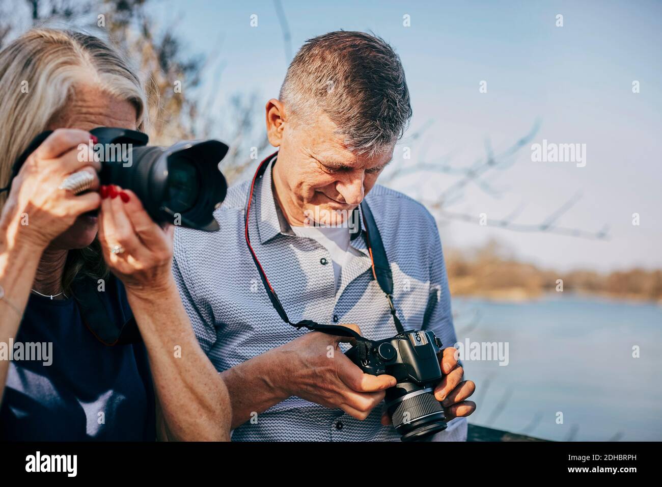 Uomo anziano e donna con telecamere al parco Foto Stock