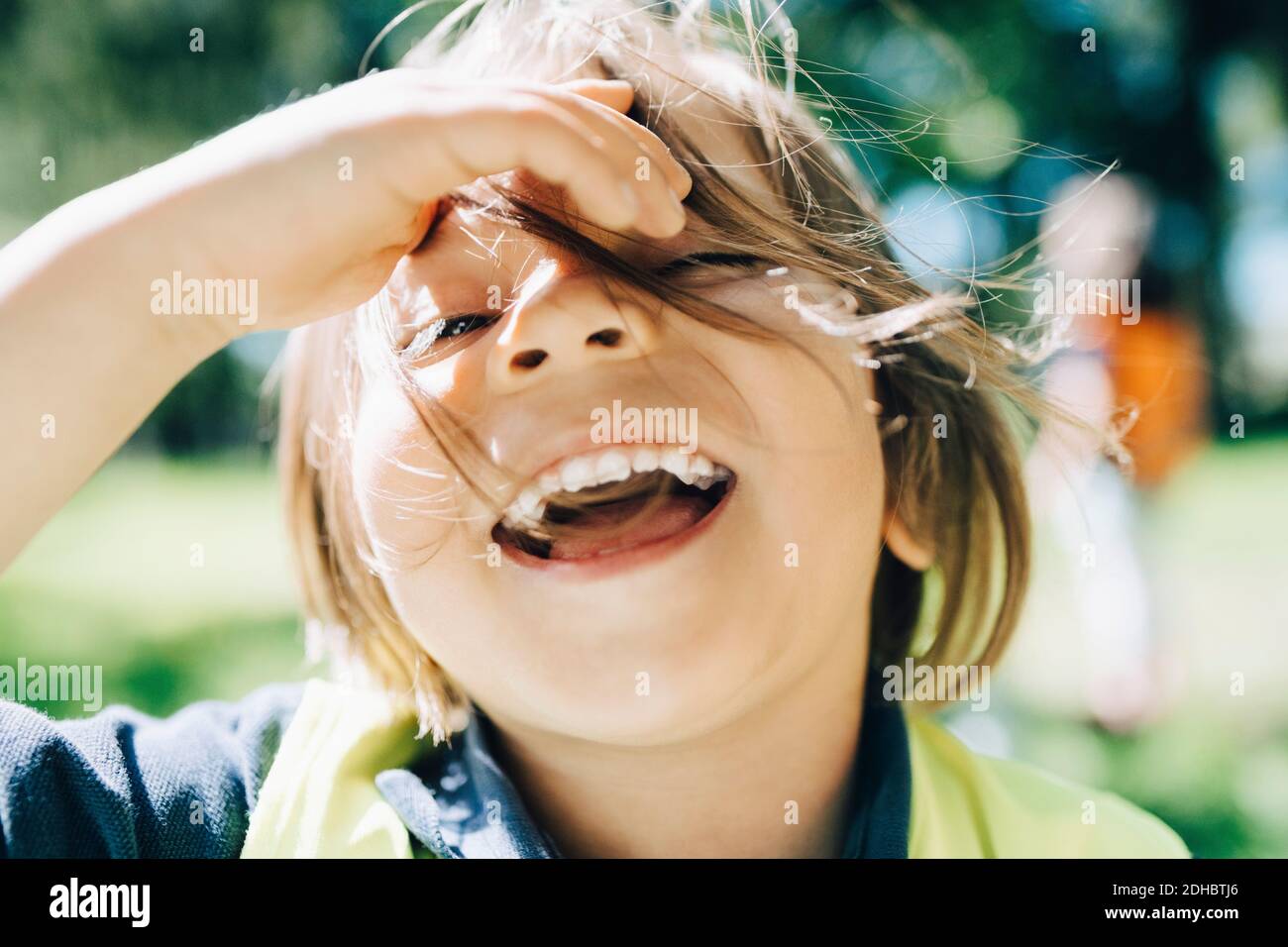 Ritratto di ragazzo allegro con capelli tosati nel parco giochi Foto Stock