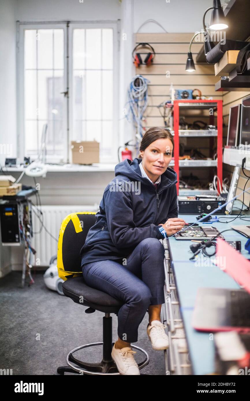 Ritratto di una donna matura che siede in un negozio di elettronica Foto Stock