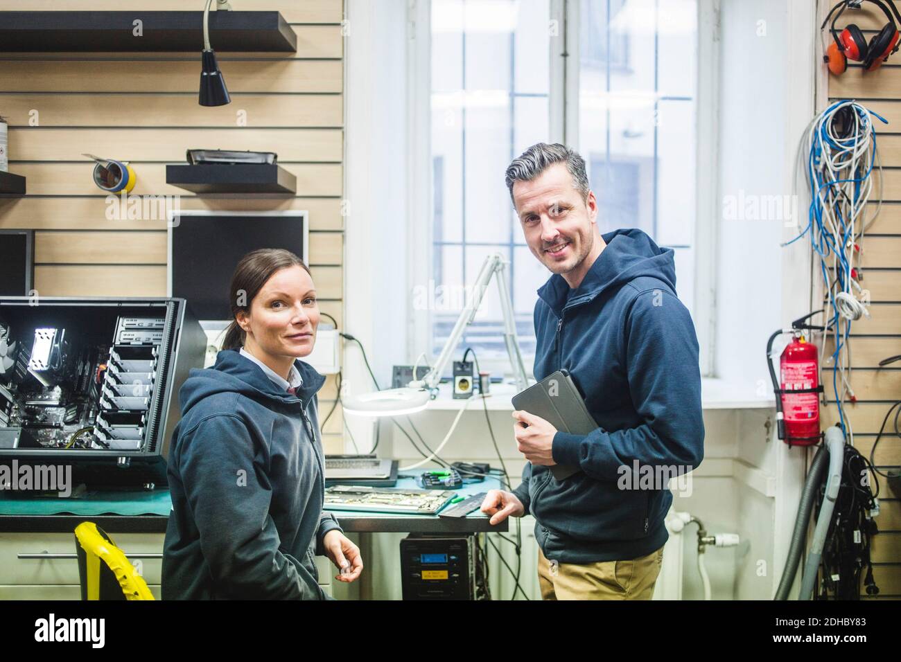 Ritratto di ingegneri informatici sorridenti e sicuri che lavorano in un negozio di elettronica Foto Stock