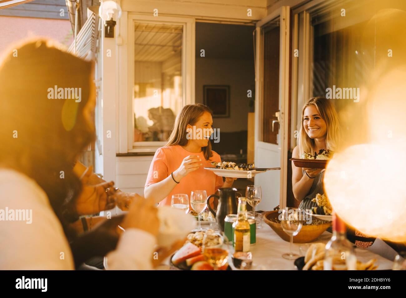 Amici felici che gustano il cibo al tavolo da pranzo in cena festa Foto Stock