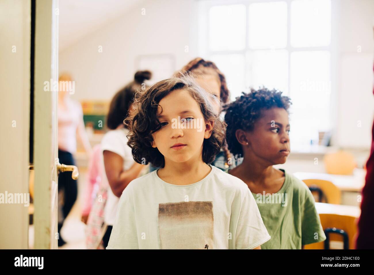 Gli studenti si allineano alla porta in classe Foto Stock