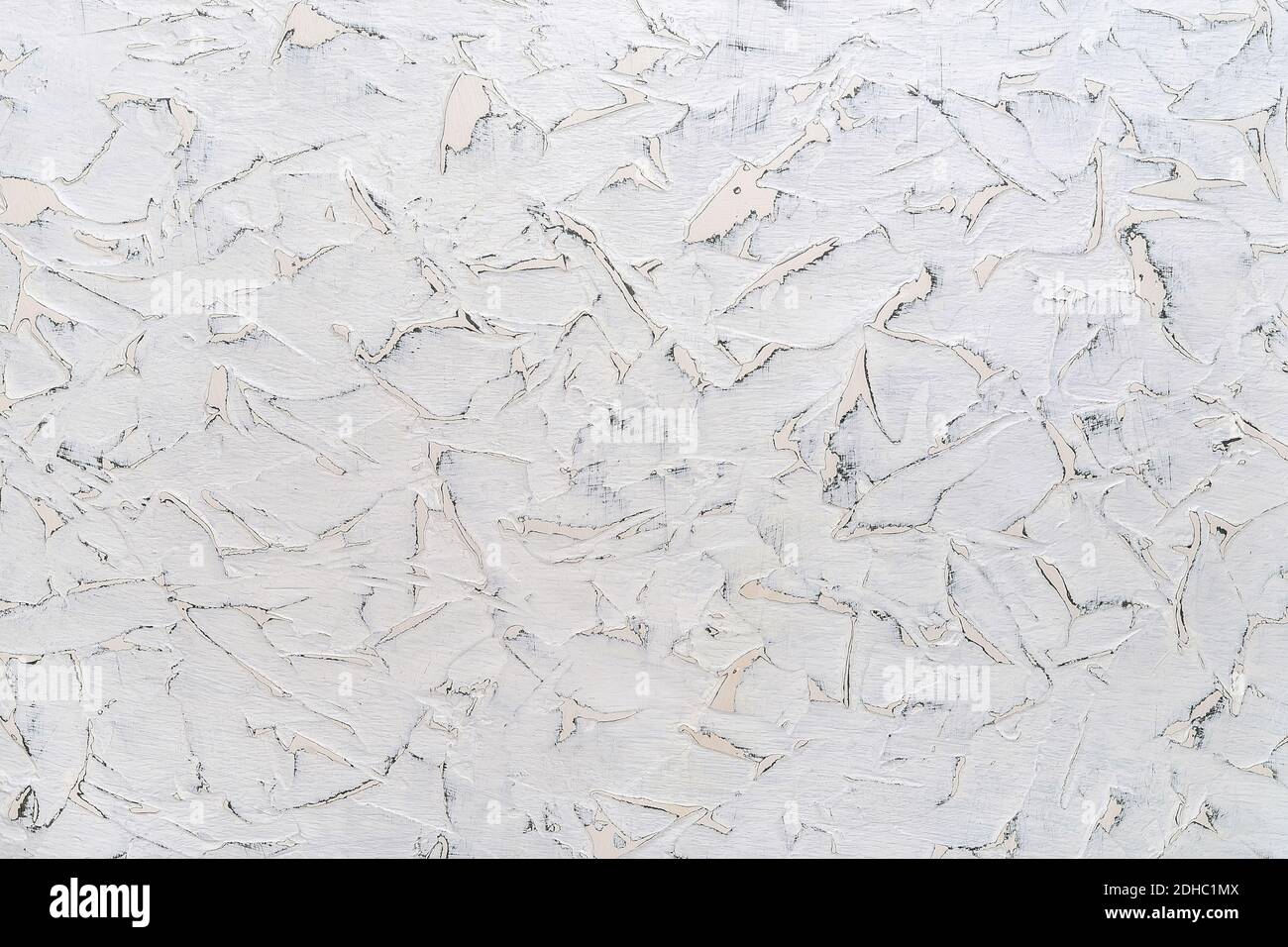 Struttura di vernice bianca incrinata su una superficie con macchie di forme diverse. Parete bianca invecchiata con graffi grigi. Contesto di costruzione astratto. Foto Stock