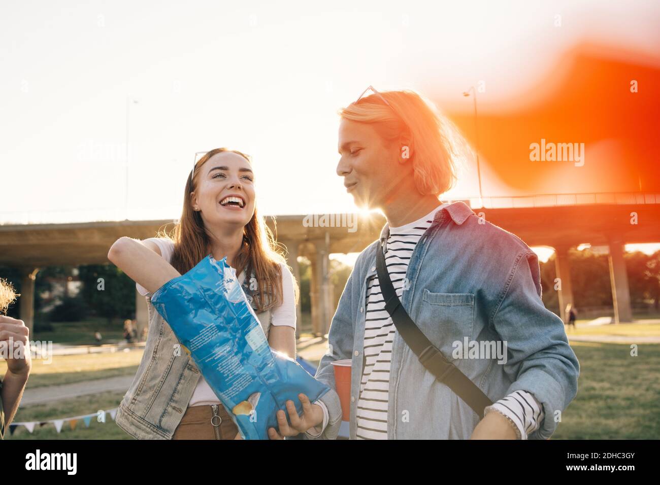 Uomo che dà pacchetti chip alla donna felice all'evento musicale Foto Stock
