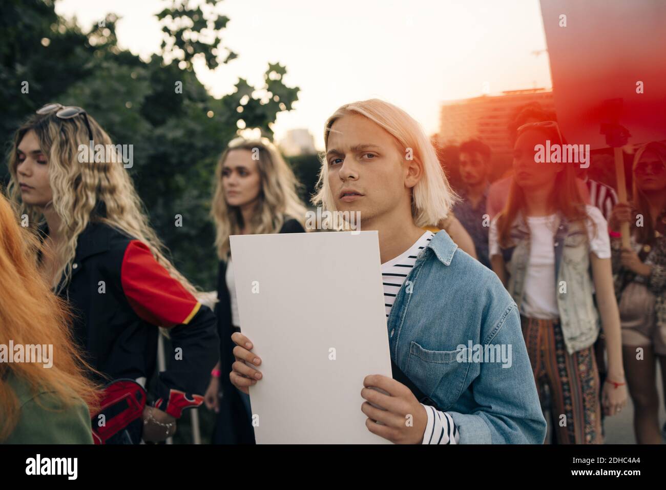 Ritratto di giovane con amici che protestano in città Foto Stock