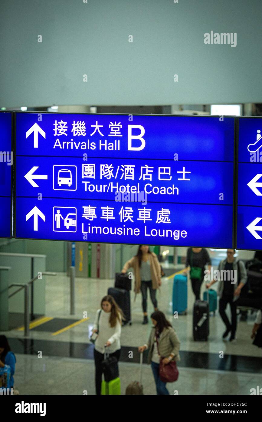 Cartello per gli arrivi all'aeroporto di Hong Kong con i passeggeri Foto Stock