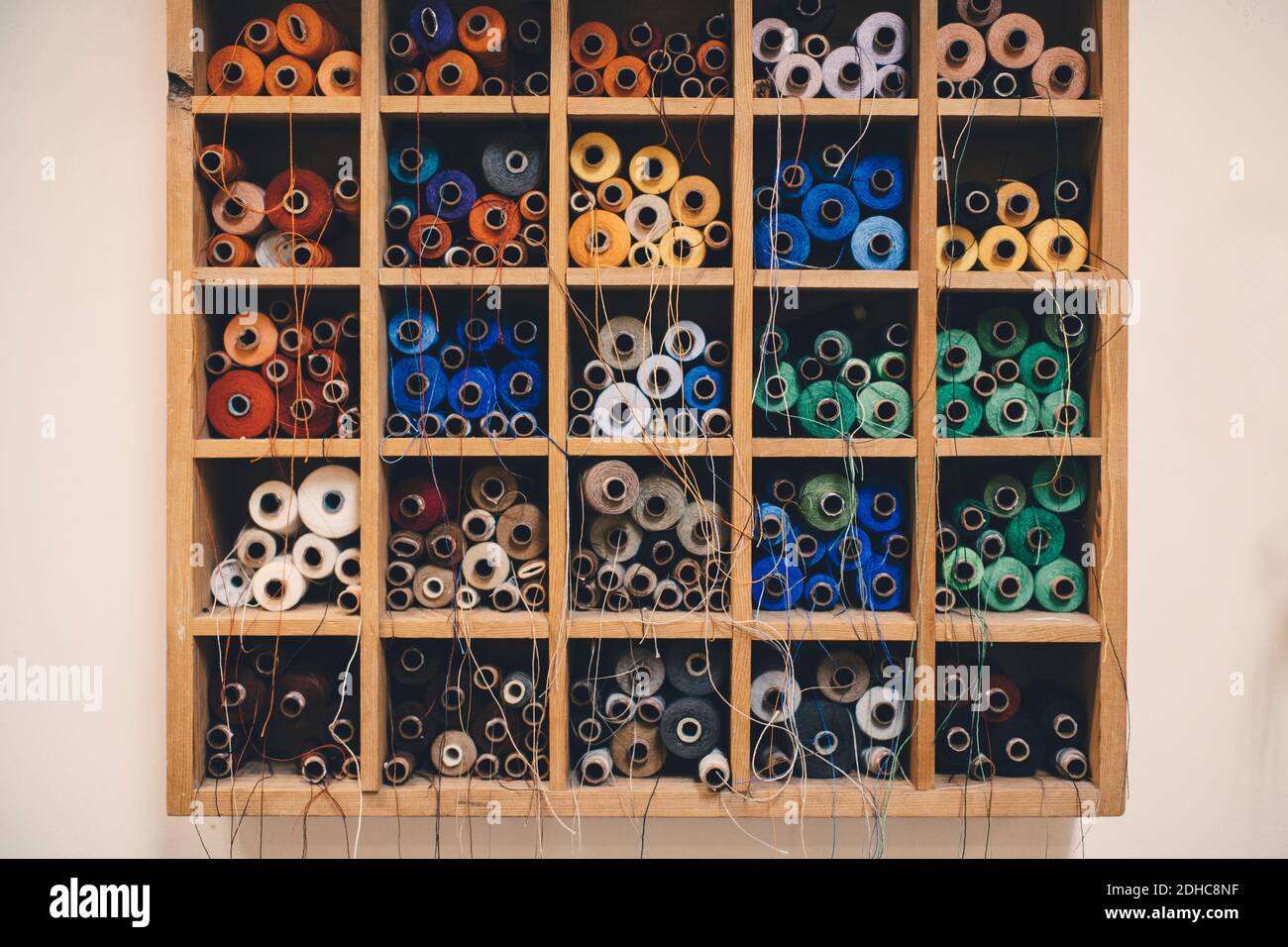 Bobine colorate in rack presso l'officina di tappezzeria Foto Stock
