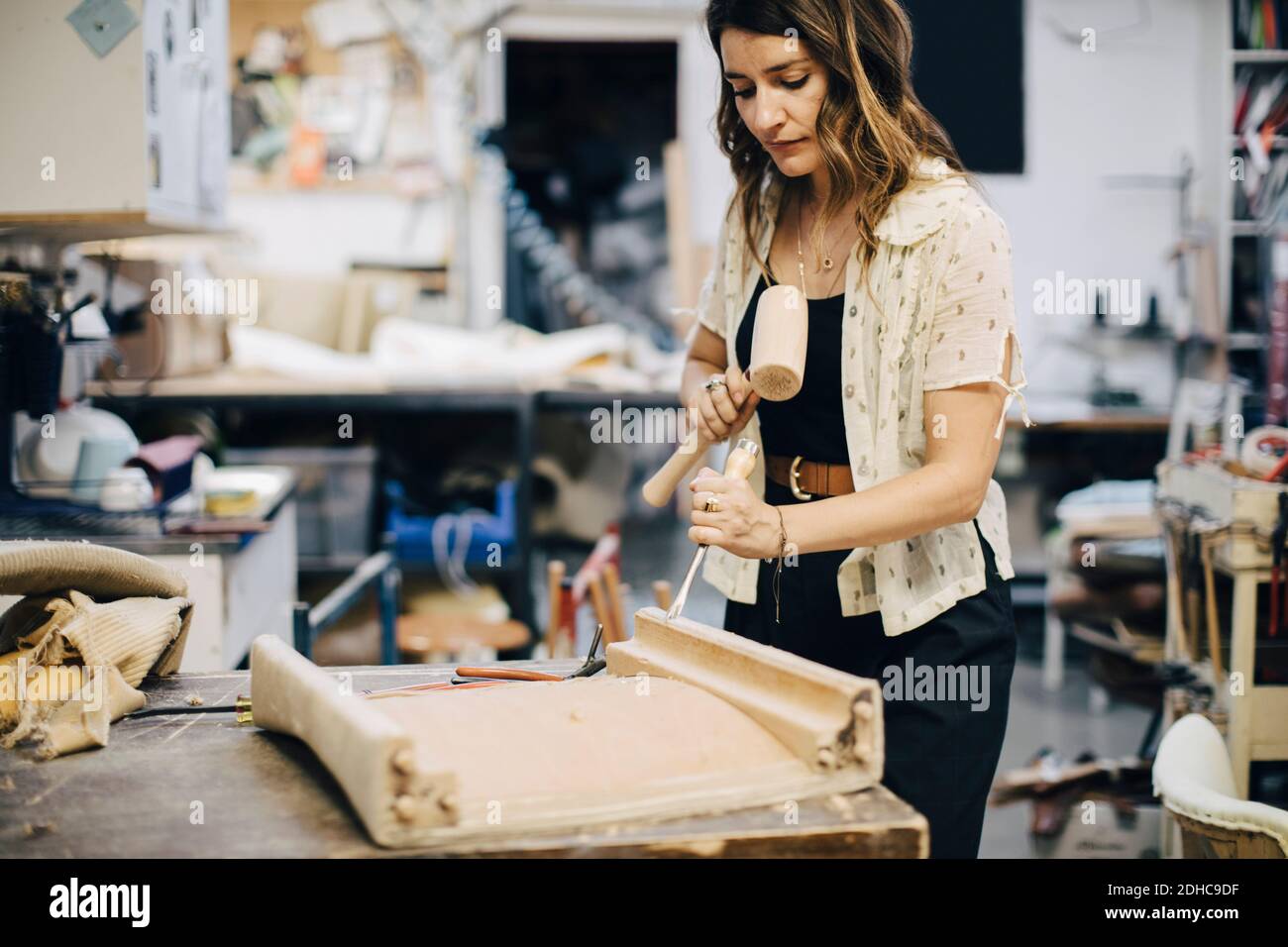 Donna imprenditore che fa mobili in officina Foto Stock