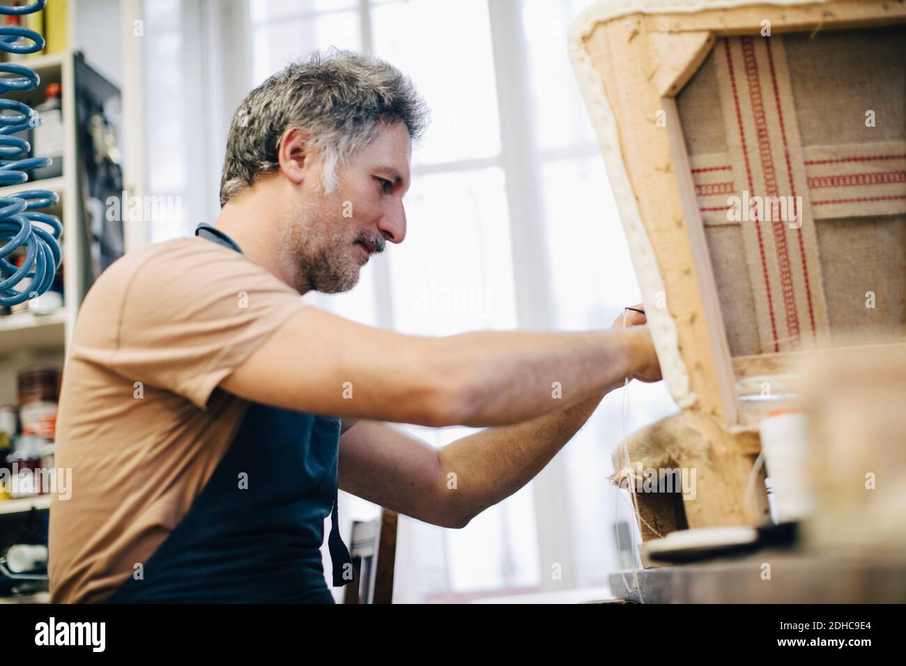 Maturo artigiano che fa mobili in officina Foto Stock