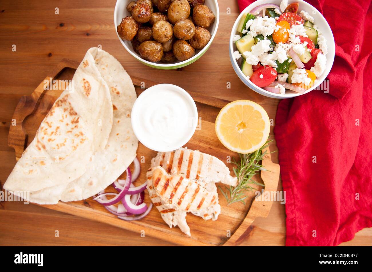 Pollo pita wrap con pomodoro e patate tzatziki e un lato insalata greca Foto Stock