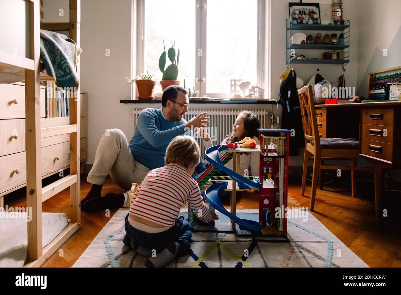 Padre e figlie che giocano in camera da letto a casa Foto Stock