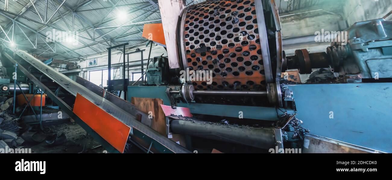 Fabbrica di riciclaggio della gomma, attrezzature industriali e linea di trasporto con pneumatici usati tagliati. Riciclaggio dei rifiuti. Foto Stock