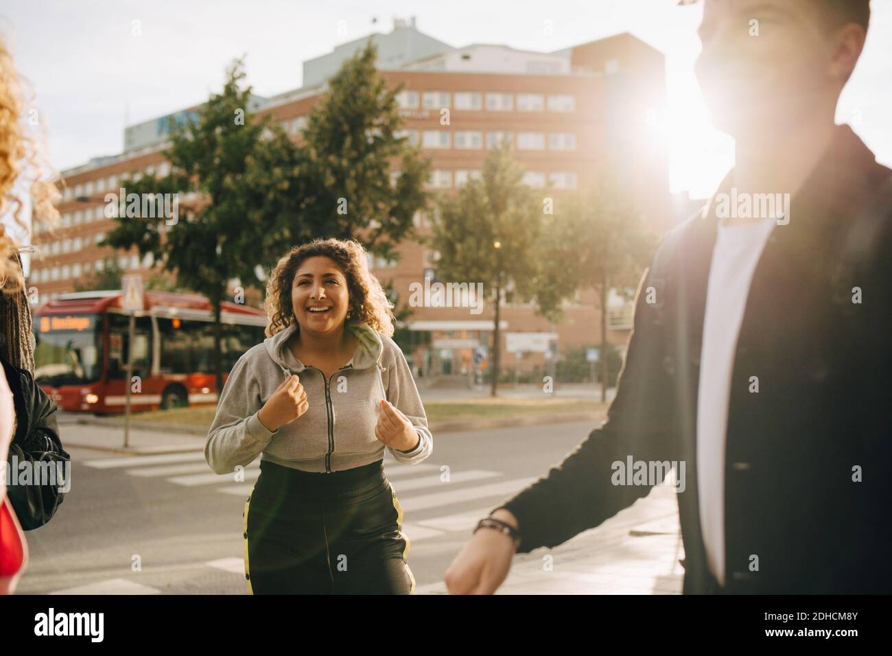 Sorridente uomo e donna che parlano mentre si è in piedi per strada città Foto Stock