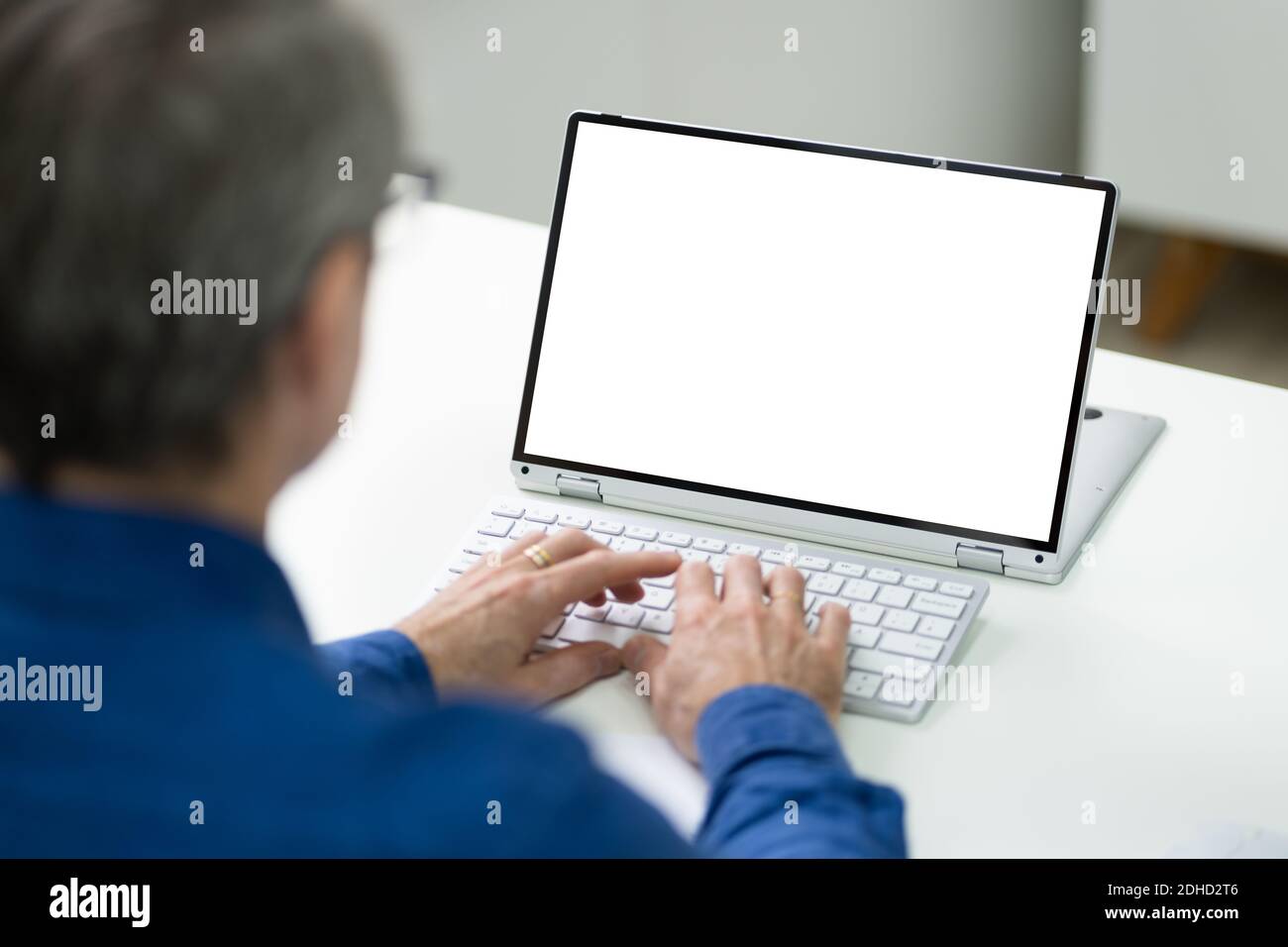 Uomo con schermo vuoto per laptop alla scrivania in ufficio Foto Stock