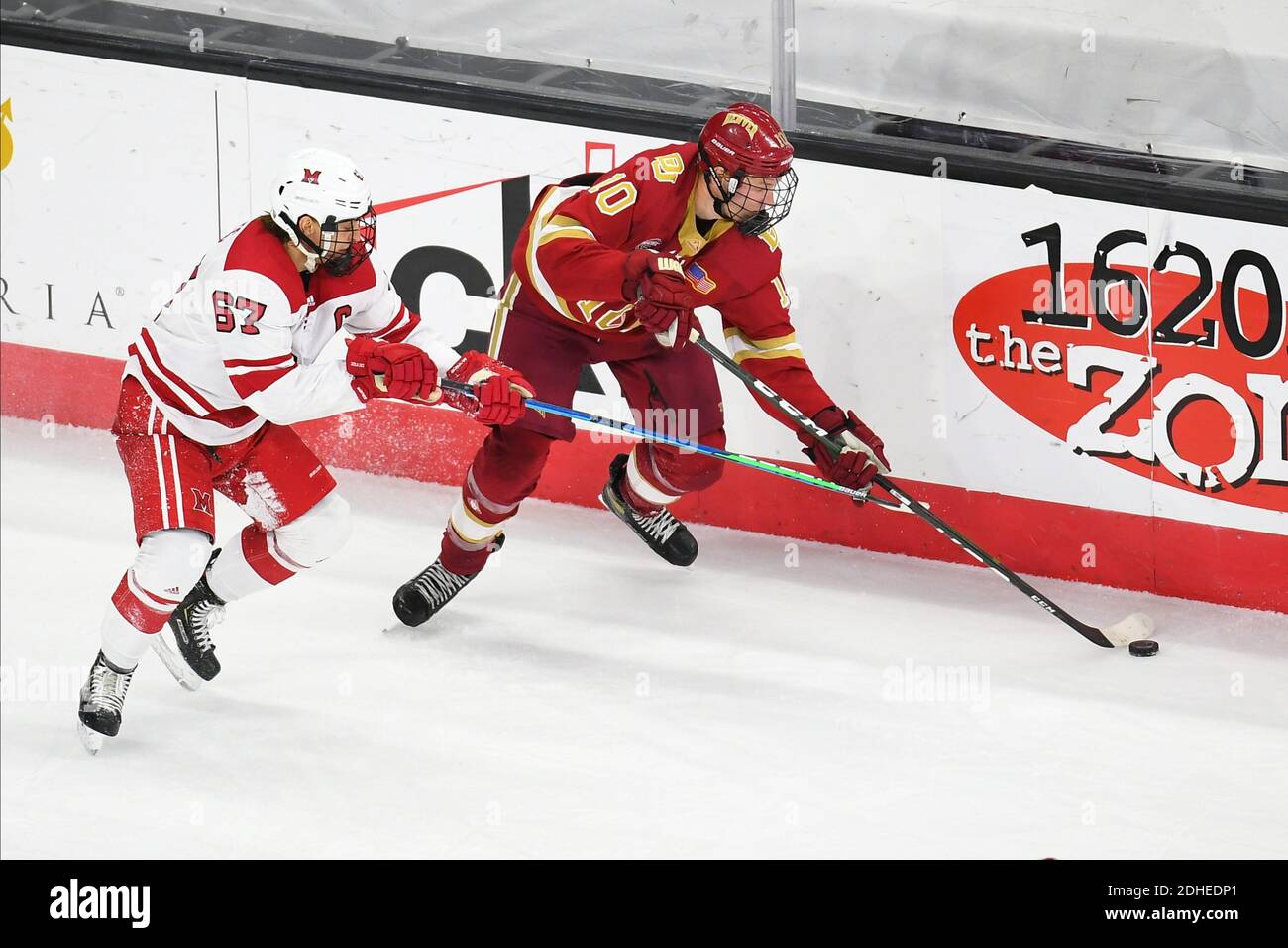 10 dicembre 2020 Miami Redhawks forward Phil Knies (67) tenta di rallentare i Denver Pioneers in avanti Jaakko Heikkinen (10) durante una partita di hockey maschile NCAA D1 tra i Denver University Pioneers e i Miami University Redhawks presso l'arena Baxter di Omaha, Nebraska, sede della NCHC ''Pod'', dove le prime 38 partite della National Collegiate Hockey Conference vengono giocate in condizioni sicure per proteggersi dal Covid-19. Denver ha vinto 5 a 1. Foto di Russell Hons/CSM Foto Stock