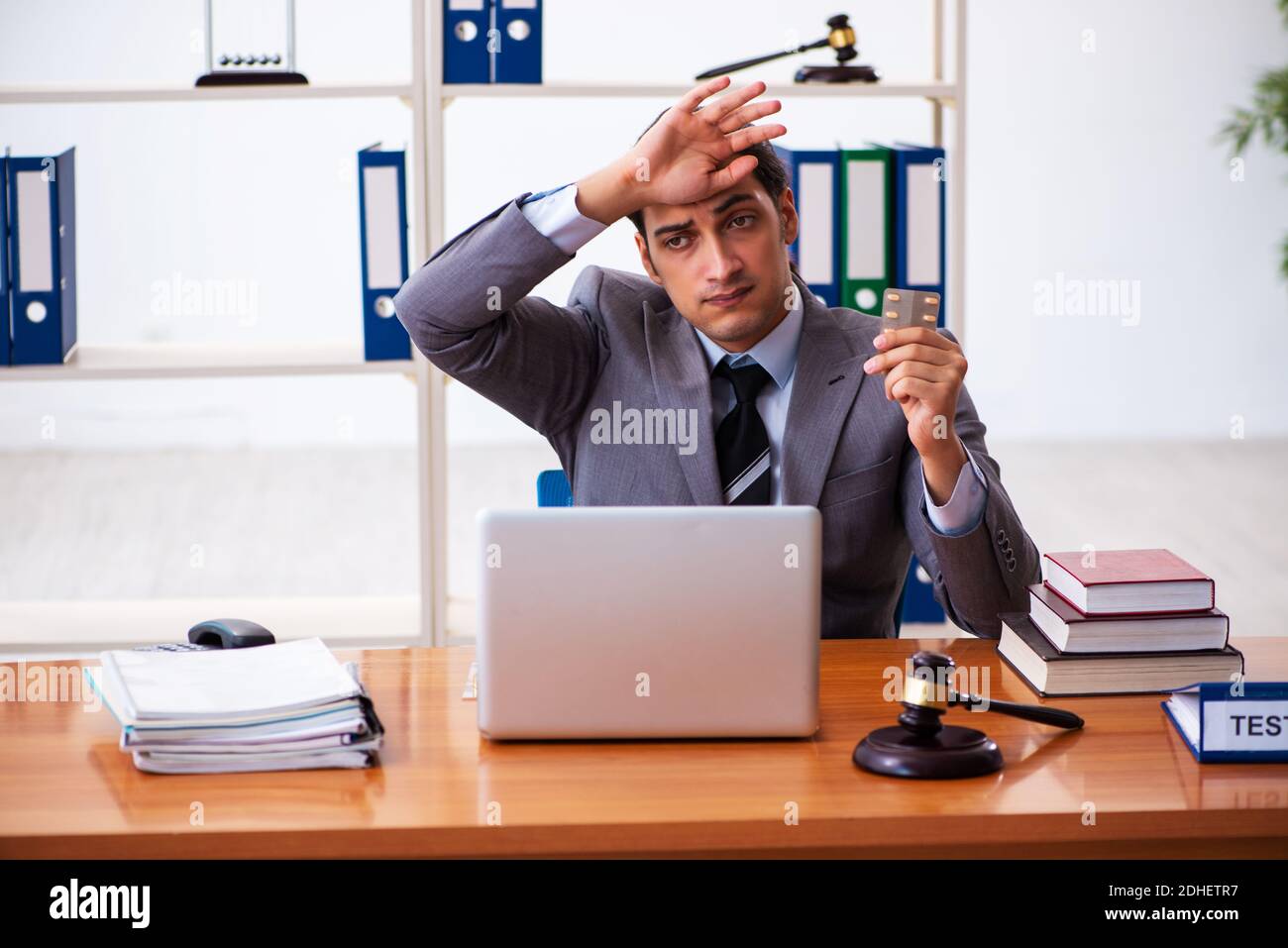 Giovane avvocato maschile seduto in ufficio Foto Stock