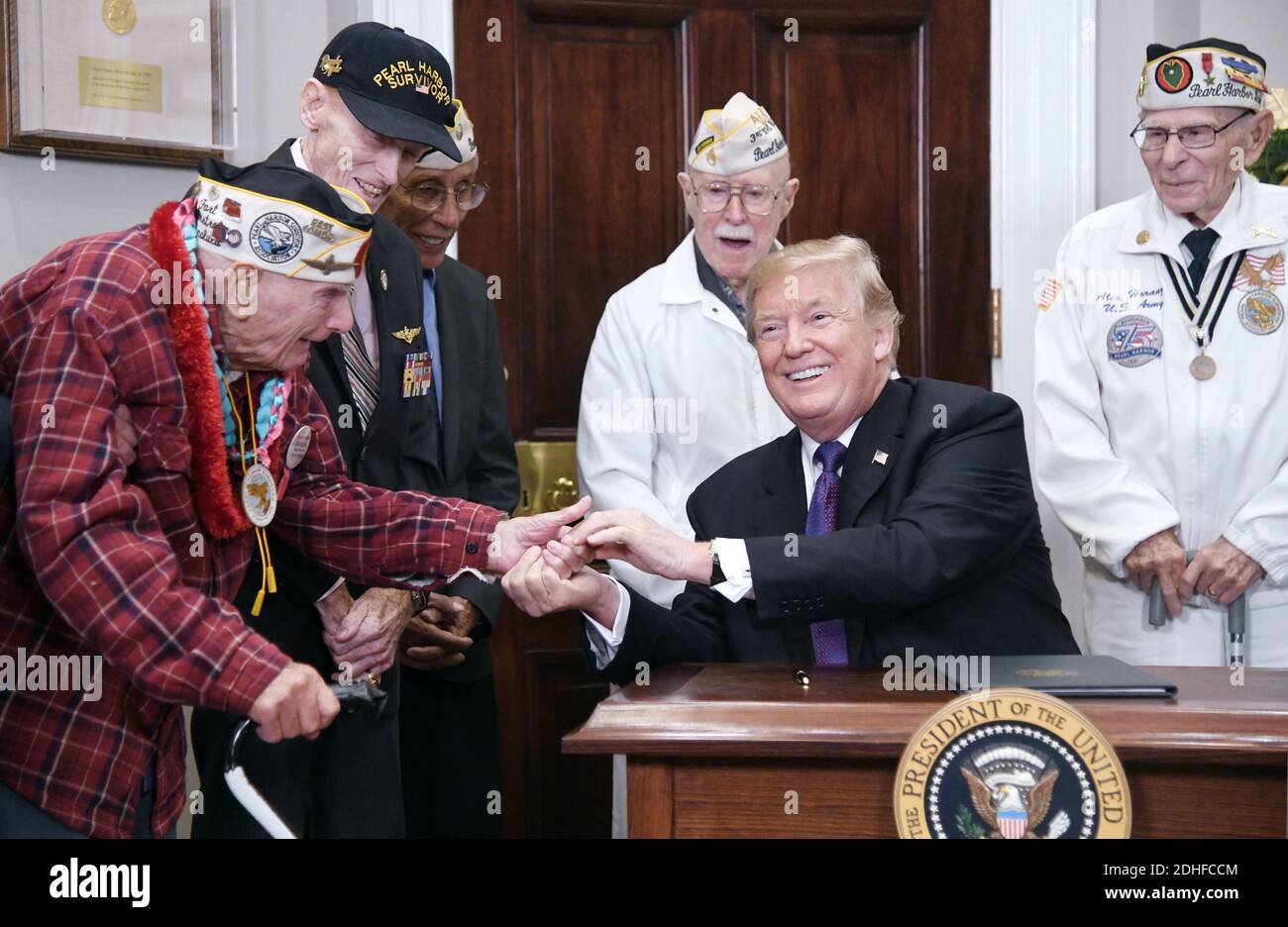 Il presidente degli Stati Uniti Donald Trump affiancato da veterani condivide una risata con Lawrence Parry (L), Private , United States Army, dopo aver firmato un annuncio per il National Pearl Harbor Remembrance Day nella Roosevelt Room della Casa Bianca , il 7 dicembre 2017 a Washington, DC, USA. Foto di Olivier Douliery/ABACAPRESS.COM Foto Stock