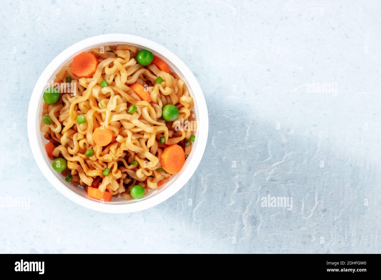 Tagliatelle istantanee in una tazza di plastica, sparate dall'alto Foto Stock