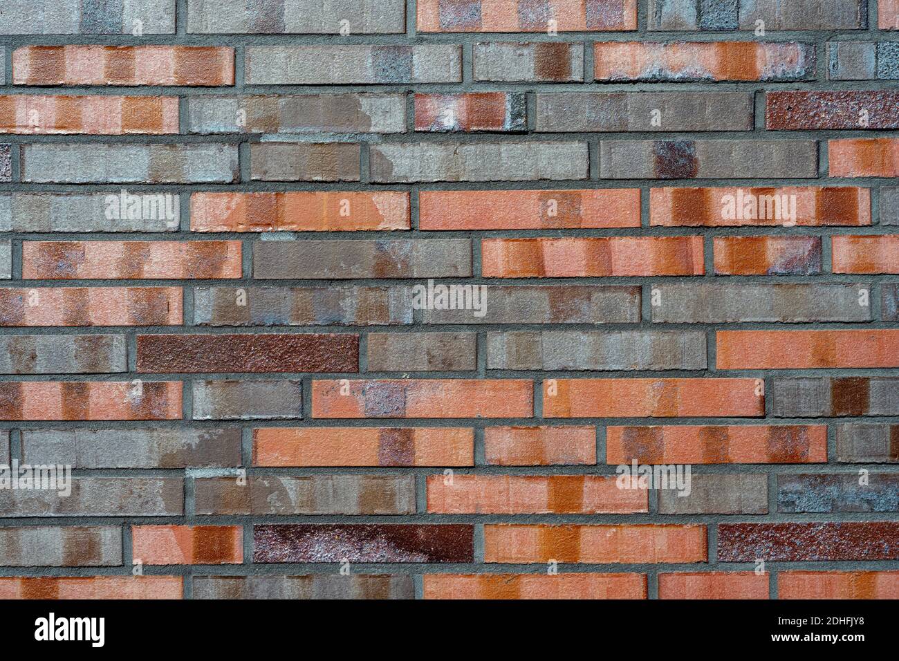 Sfondo di un muro di mattoni con diverse sfumature di rosso Foto Stock