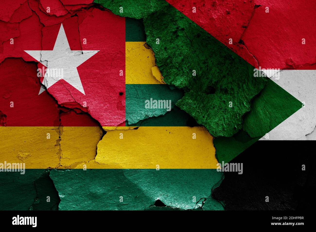 Bandiere di Togo e Sudan dipinte su pareti incrinate Foto Stock