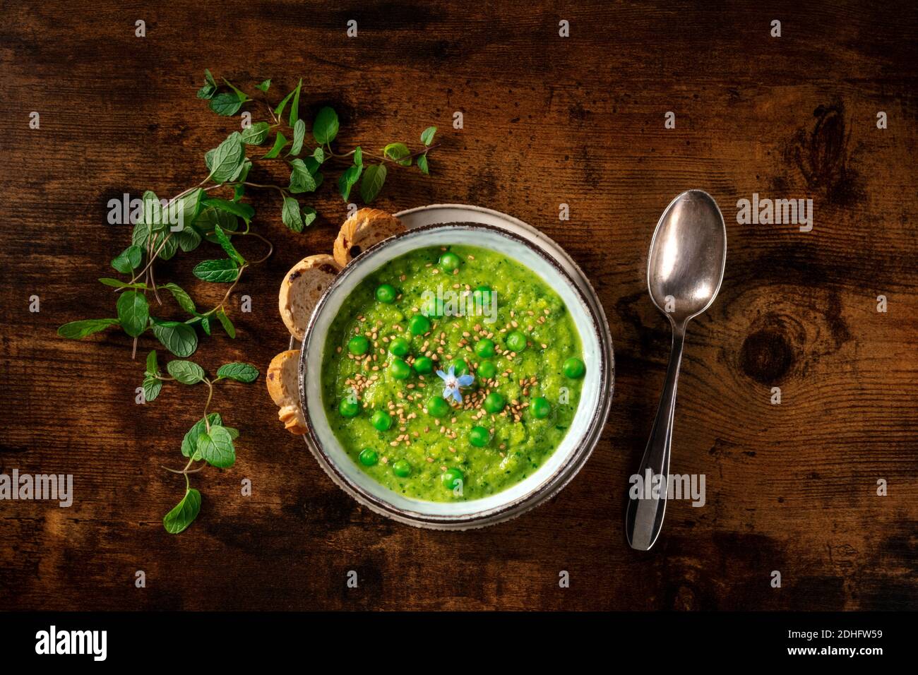 Zuppa verde vegana, sparata dall'alto con toast e menta Foto Stock