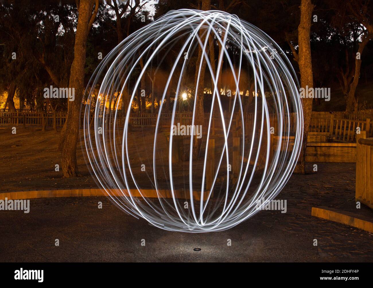 Sperimenta usando le torce nel parco per creare una palla di luce. La fotocamera con un otturatore aperto. Fotografato a Guardamar, Alicante, Spagna. Foto Stock