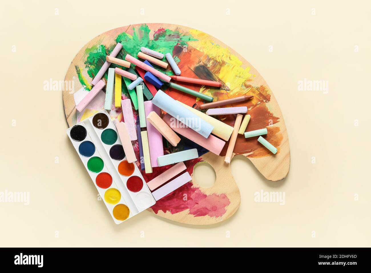 Gessetti colorati con vernice e tavolozza su sfondo colorato Foto
