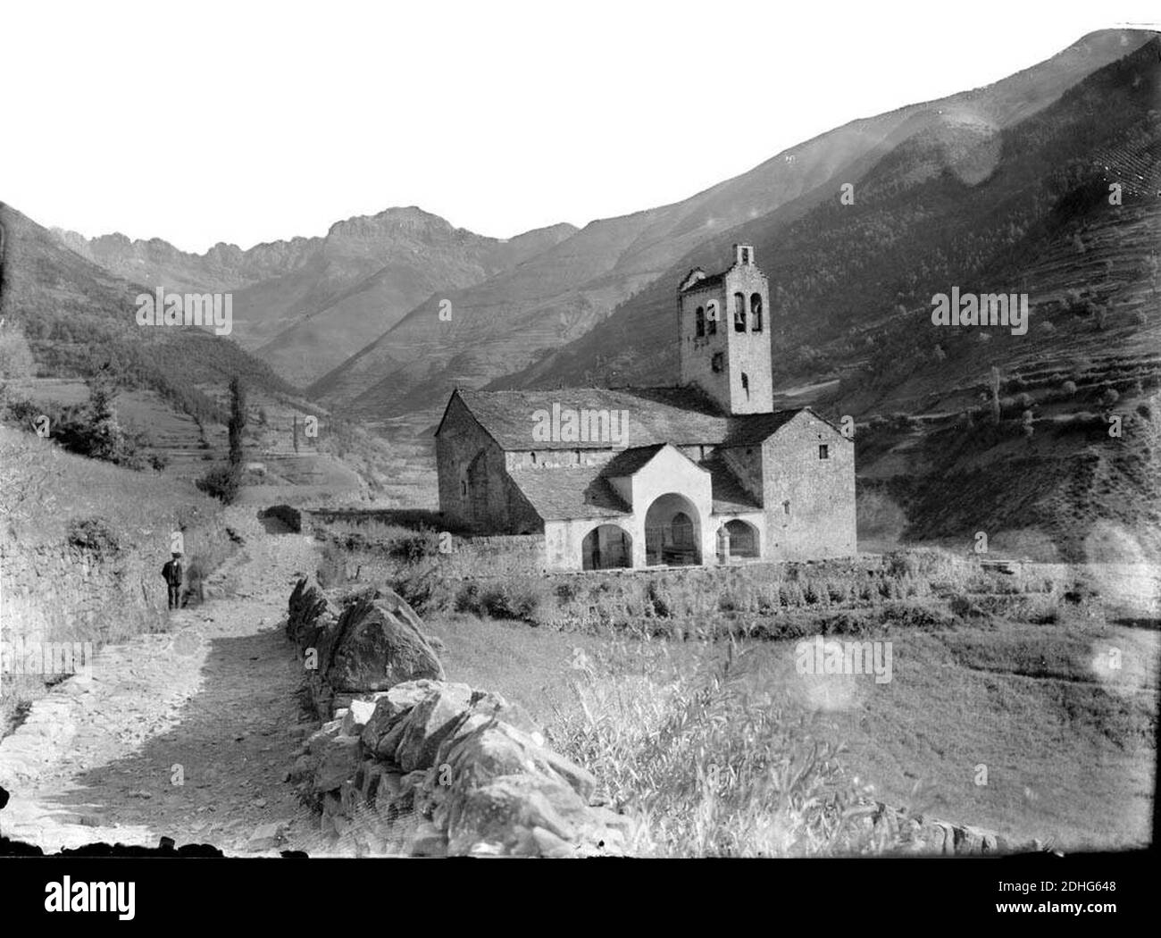 L'església de Linás de Broto al mig de la vall i un home al camí. Foto Stock