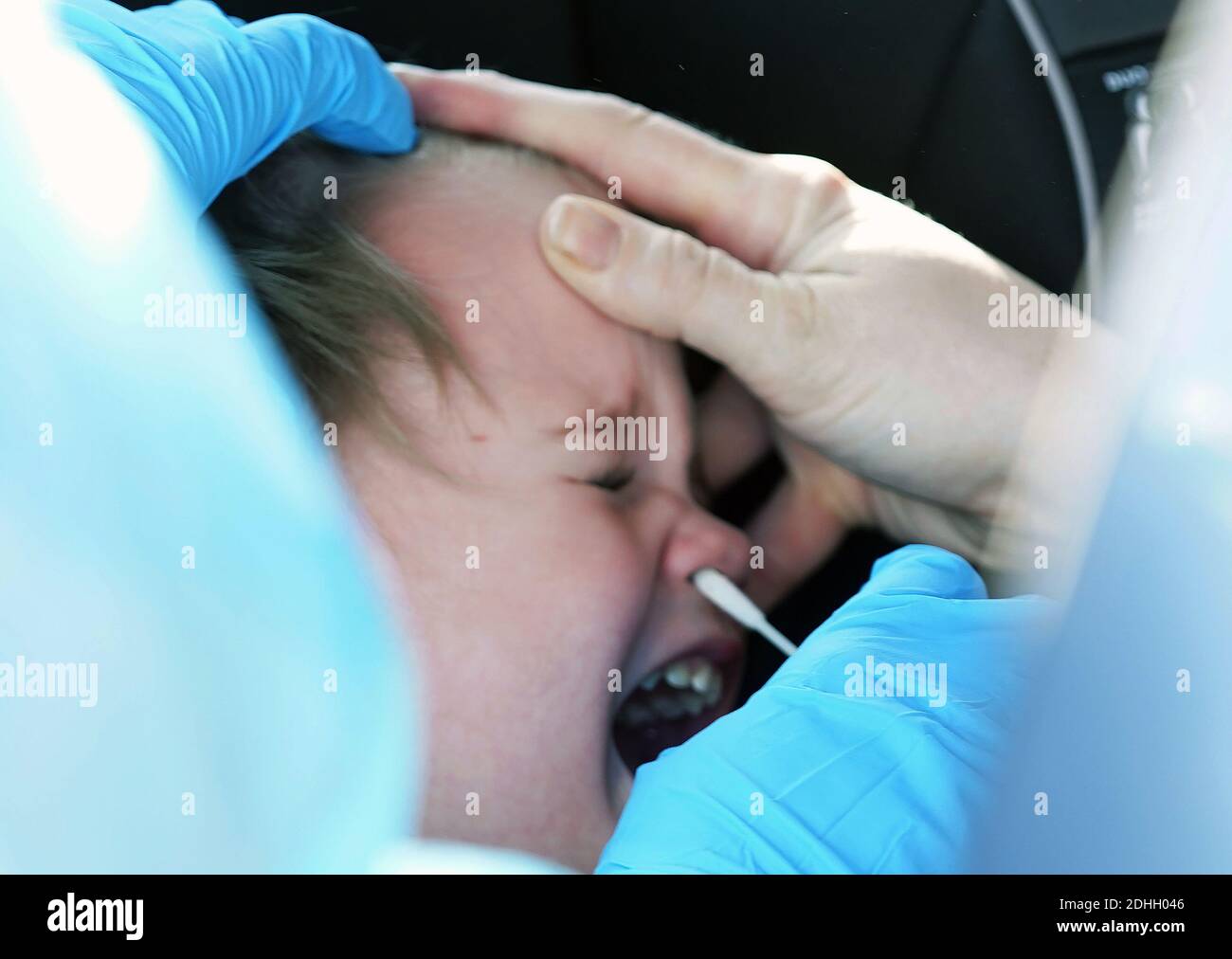 St. Charles, Stati Uniti. 10 dicembre 2020. Ashley Origel, specialista della Guardia Nazionale del Missouri, ha la testa di un ragazzo piangente mentre esegue un test COVID-19 durante i test di guida presso la Family Arena di St. Charles, Missouri, giovedì 10 dicembre 2020. La Guardia Nazionale del Missouri ha assistito, testando quasi 400 persone al giorno. Photo by Bill Greenblatt/UPI Credit: UPI/Alamy Live News Foto Stock