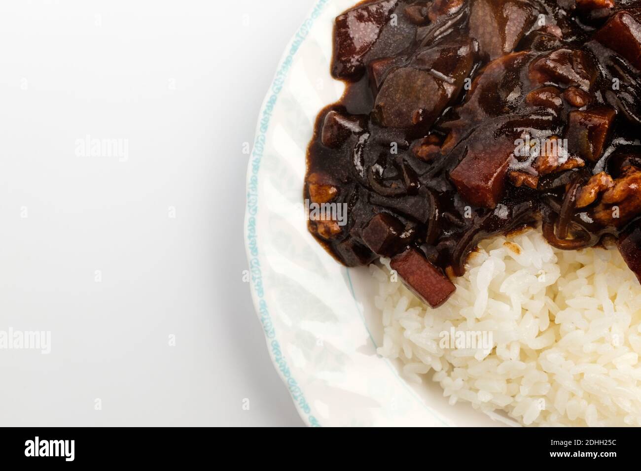 Riso Jjajang in un piatto su fondo bianco Foto Stock