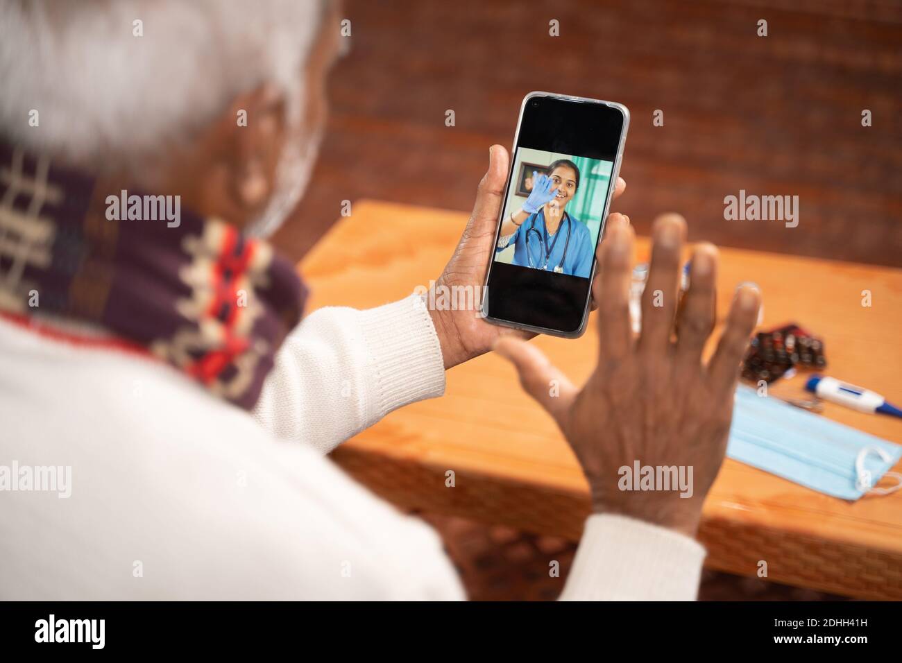 Spalla colpo di vecchio uomo in video con al medico sul telefono cellulare - concetto di infermiera Chat online, telegHealth, o consulenza telefonica durante il coronavirus o. Foto Stock
